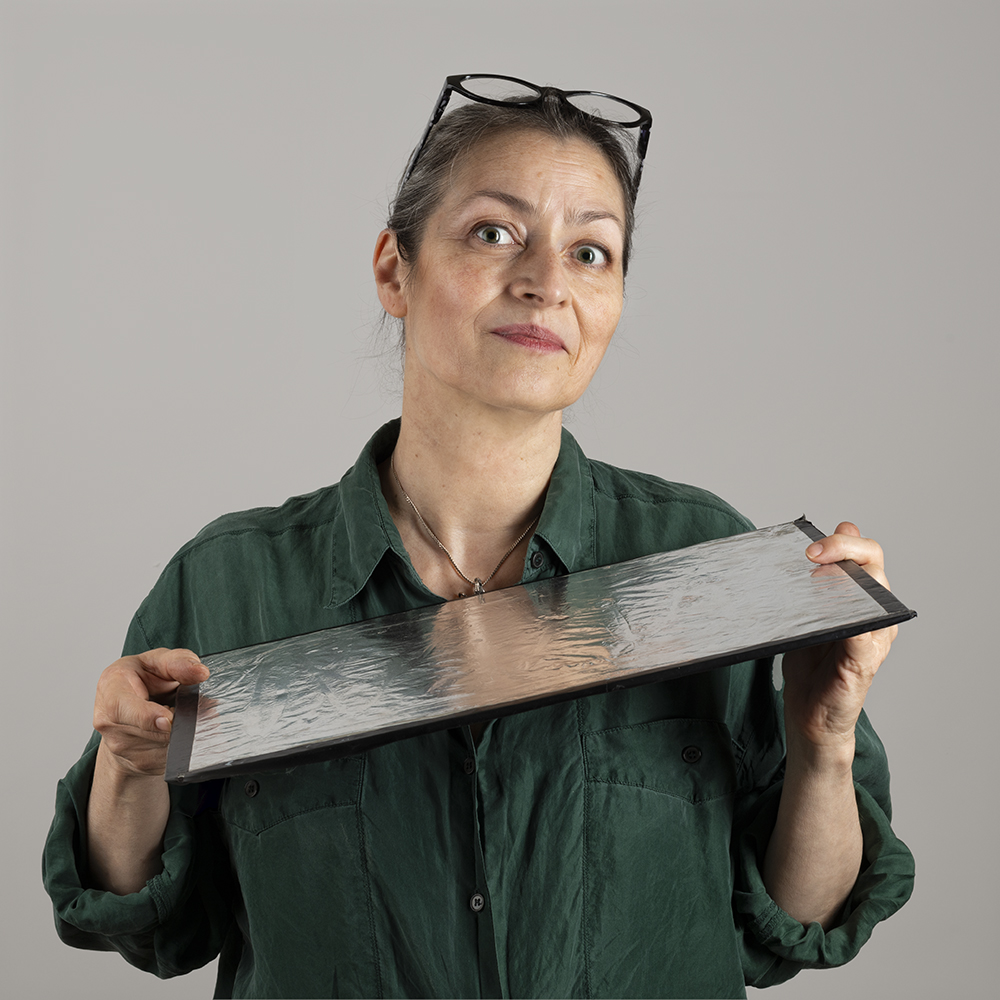 Image of photographer holding reflecting board beneath her chin.